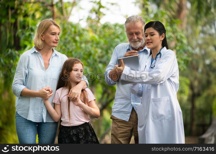 Happy healthy family and doctor talking in the park. People healthcare and medical staff service concept.