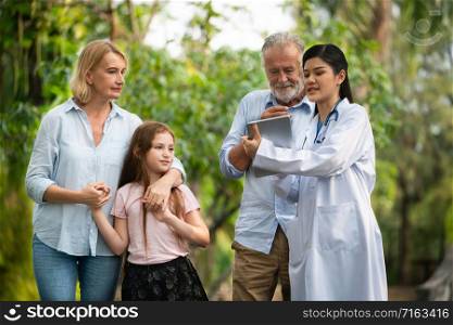 Happy healthy family and doctor talking in the park. People healthcare and medical staff service concept.