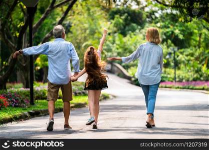 Happy healthy family walk together on path in the park in summer. Concept of family bonding.. Happy healthy family walk together in the park.