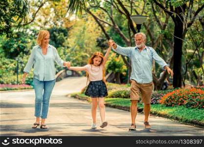 Happy healthy family walk together on path in the park in summer. Concept of family bonding.. Happy healthy family walk together in the park.