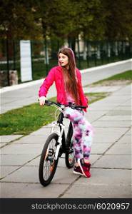 Happy hipster girl with bike in the city. Toned and filtered photo. Modern youth lifestyle concept.