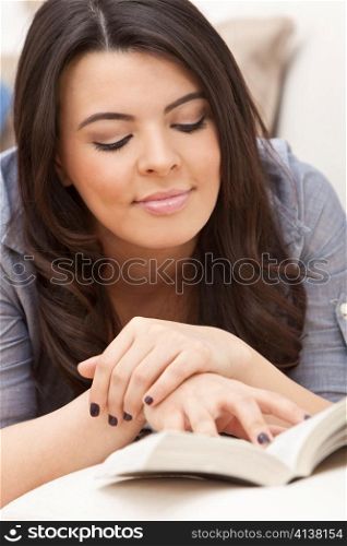 Happy Hispanic Woman Reading Paperback Book at Home