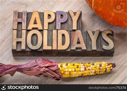Happy Holidays banner or greeting card in vintage letterpress wood type with pumpkin and corn