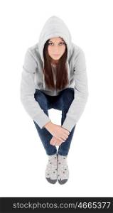Happy hooded girl with grey sweatshirt sitting on the floor isolated