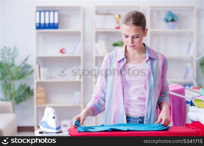 Happy housewife doing ironing at home