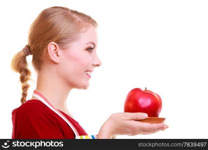 Happy housewife or chef in colorful kitchen offering red apple healthy fruit isolated studio shot. Diet and nutrition.