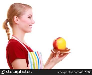 Happy housewife or chef in colorful kitchen offering red yellow apple healthy fruit isolated studio shot. Diet and nutrition.