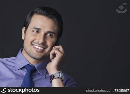 Happy Indian businessman using mobile phone over white background