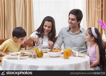 Happy Indian family having pizza together at restaurant