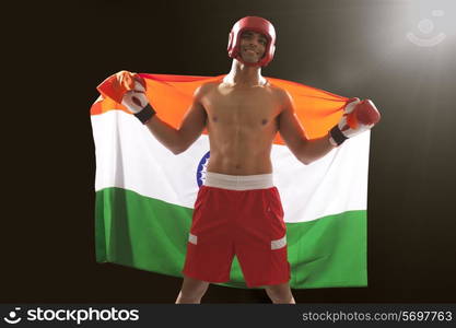 Happy Indian male boxer with national flag standing against black background