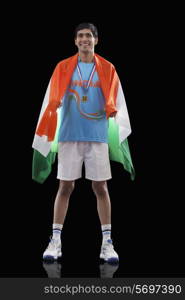 Happy Indian man in sportswear with Indian flag over black background