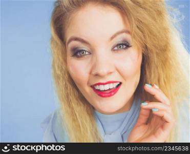 Happy joyful blonde woman with cruly hair close up. Female having beautiful make up.. Woman having colorful make up