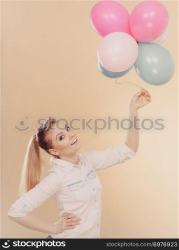 Happy joyful girl playing with colorful balloons. Holidays, celebration and lifestyle concept. Studio shot on bright. joyful girl playing with colorful balloons