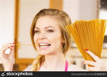 Happy joyful woman holding long pasta macaroni ready to cook. Healthy food concept.. Woman holding long pasta
