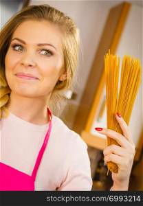 Happy joyful woman holding long pasta macaroni ready to cook. Healthy food concept.. Woman holding long pasta