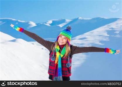 Happy joyful woman with raised hands enjoying beauty of winter nature, spending leisure time in the snowy mountains