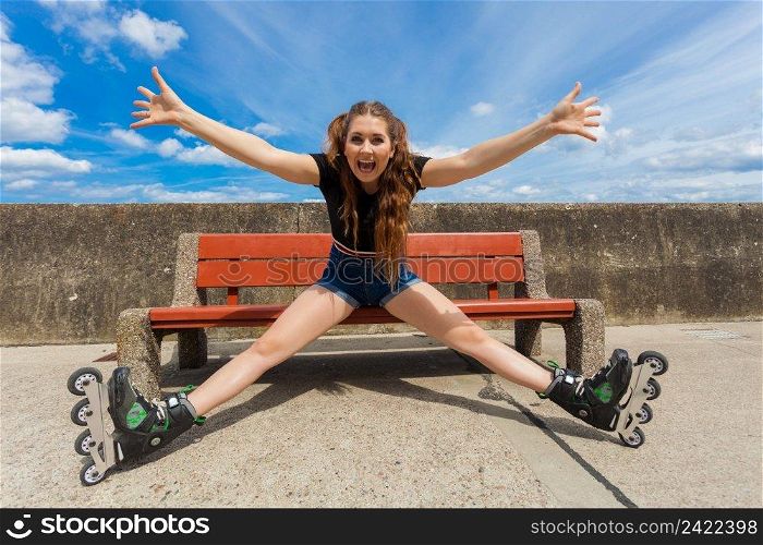 Happy joyful young woman wearing roller skates relaxing after long ride. Girl having fun during summer time near sea.. Joyful girl wearing roller skates