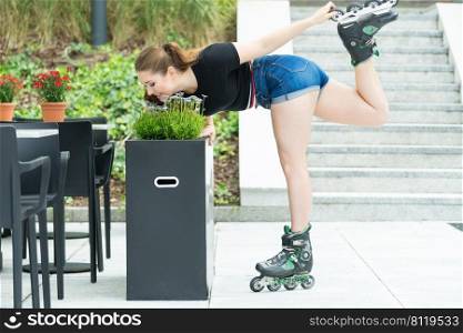 Happy joyful young woman wearing roller skates riding in town smelling flowers. Female being sporty having fun during summer time.. Young woman riding roller skates