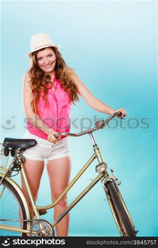 Happy joyful young woman with bike bicycle. Fashionable girl in hat, pink shirt and shorts. Summer fashion and recreation. Studio shot.