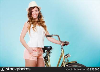Happy joyful young woman with bike bicycle. Fashionable girl in hat, white shirt and shorts. Summer fashion and recreation. Studio shot.