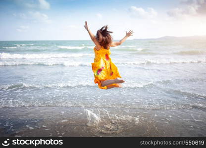 happy jumping girl on ocean beach in vocation holiday