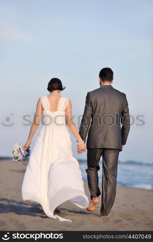 happy just married young couple celebrating and have fun at beautiful beach sunset