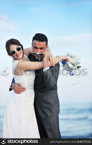 happy just married young couple celebrating and have fun at beautiful beach sunset