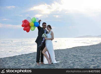 happy just married young couple celebrating and have fun at beautiful beach sunset