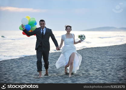 happy just married young couple celebrating and have fun at beautiful beach sunset