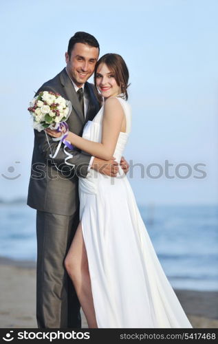 happy just married young couple celebrating and have fun at beautiful beach sunset