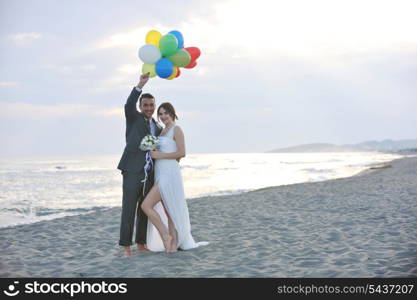 happy just married young couple celebrating and have fun at beautiful beach sunset