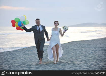 happy just married young couple celebrating and have fun at beautiful beach sunset