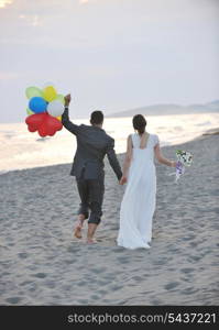 happy just married young couple celebrating and have fun at beautiful beach sunset