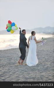 happy just married young couple celebrating and have fun at beautiful beach sunset