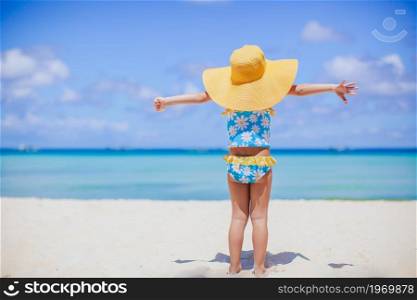 Happy kid enjoy beach tropical vacation. Adorable little girl at beach on her summer vacation