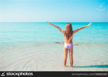 Happy kid enjoy beach tropical vacation and ready to swim. Adorable little girl at beach on her summer vacation