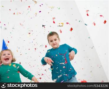 Happy kids celebrating party with blowing confetti