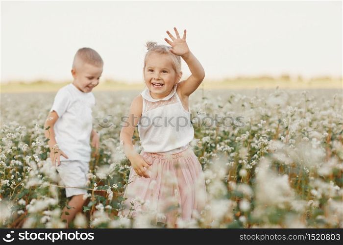 happy kids having fun in a flowering field. happy childhood. happy kids having fun in a flowering field. happy childhood.