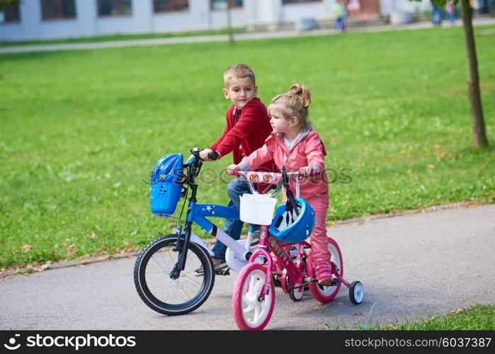 happy kids in park, boy and girl in nature with bicycle have fun