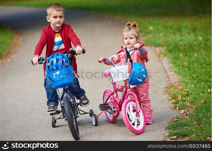 happy kids in park, boy and girl in nature with bicycle have fun