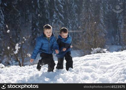 happy kids playing in fresh snow at beautiful sunny winter day