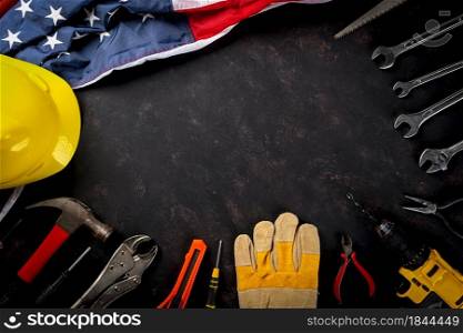 Happy Labor day. Several engineer constructor work tools and American flag with copy space on black dark background, Made in USA, American workforce concept