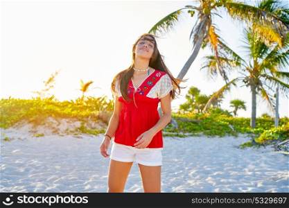Happy latin beautiful girl in caribbean palm trees sunset beach