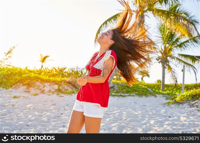 Happy latin beautiful girl jumping hair in caribbean palm trees beach