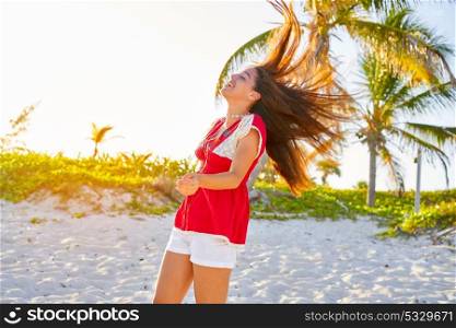 Happy latin beautiful girl jumping hair in caribbean palm trees beach