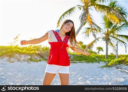 Happy latin beautiful girl open arms in caribbean palm trees beach