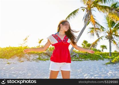 Happy latin beautiful girl open arms in caribbean palm trees beach