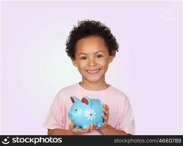 Happy latin child with a blue moneybox isolated on a purple background