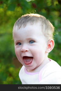 happy laughing baby outdoor on green background