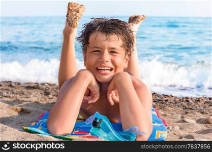 happy laughing boy of twelve with a scuba mask on the sea beach